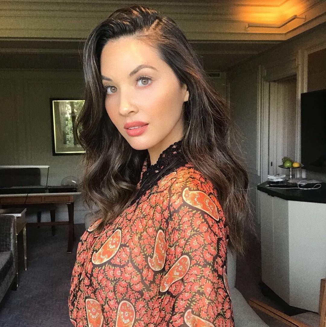 Olivia Munn with long wavy hair.