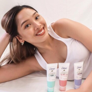 Iya Omana smiling with Dove Intensive Renew Deodorant Dry Serum products. 