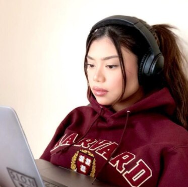 Janny Miranda with headphone on and laptop.