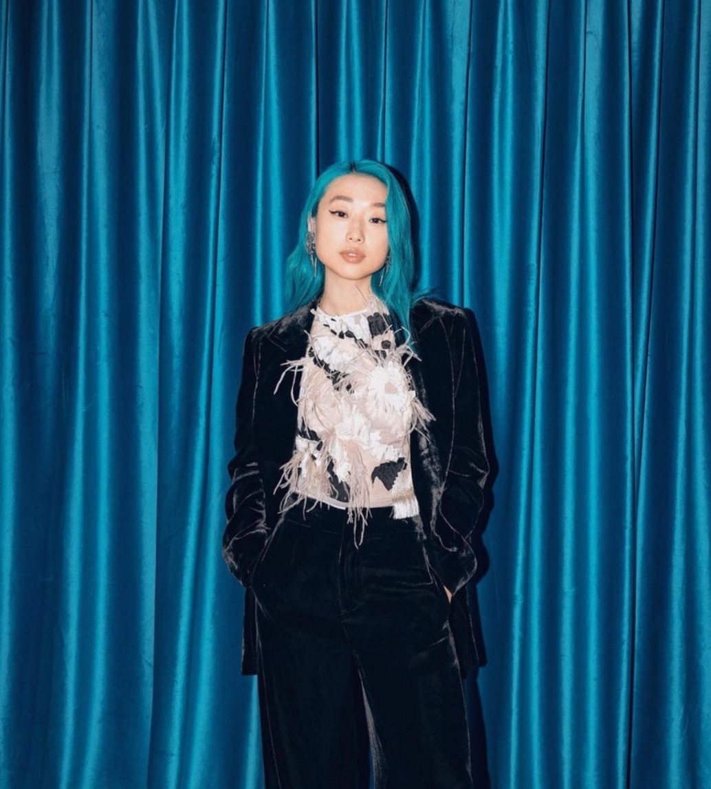 Vogue China editor in chief Margaret Zhang poses against blue curtain