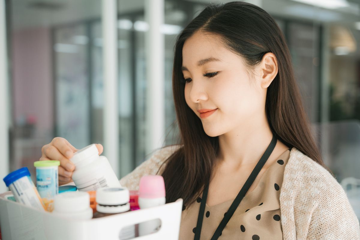 Asian woman reading the label on beauty products