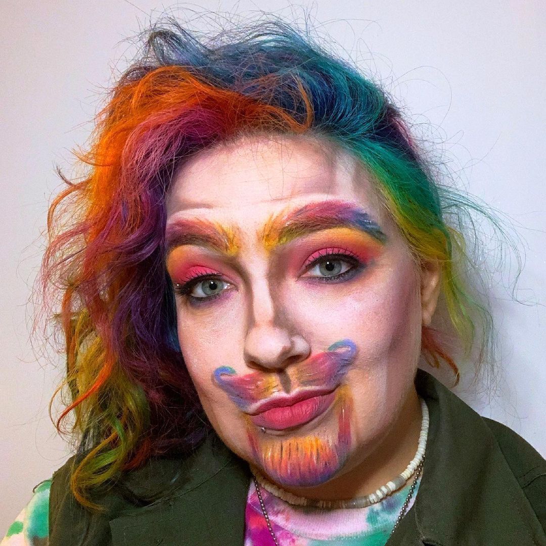 Woman with rainbow colored hair wearing rainbow face makeup