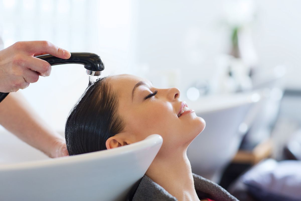 Asian woman getting her hair washed at a salon.