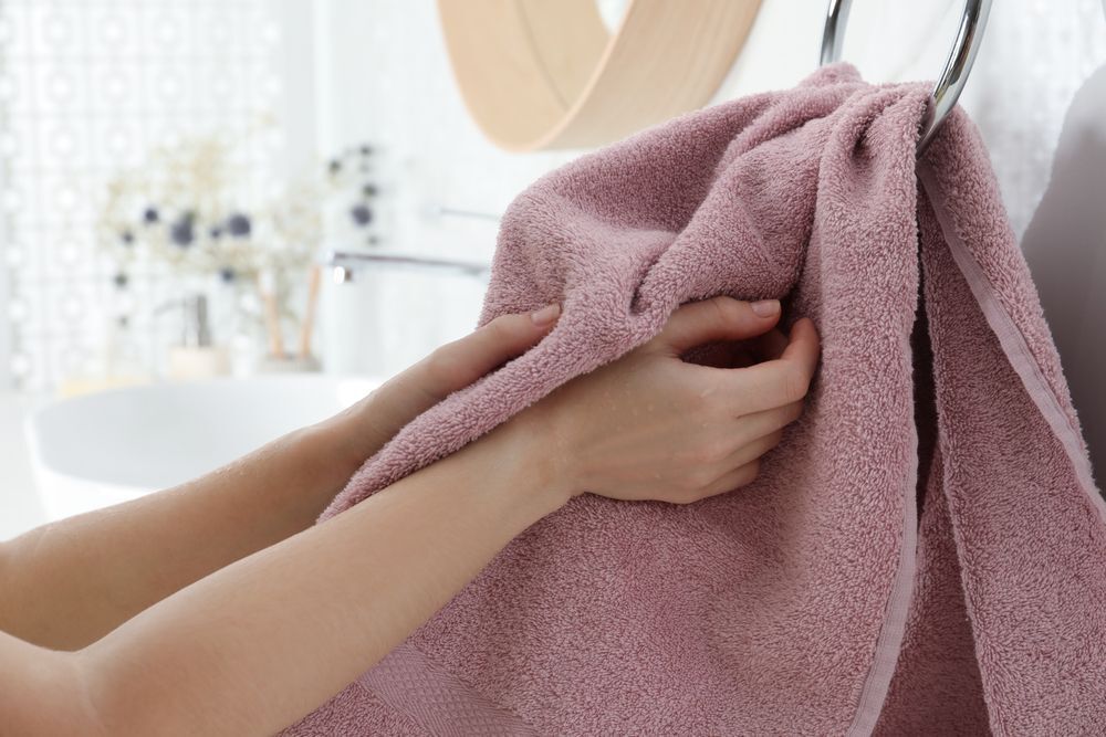 A person drying hands in a towel