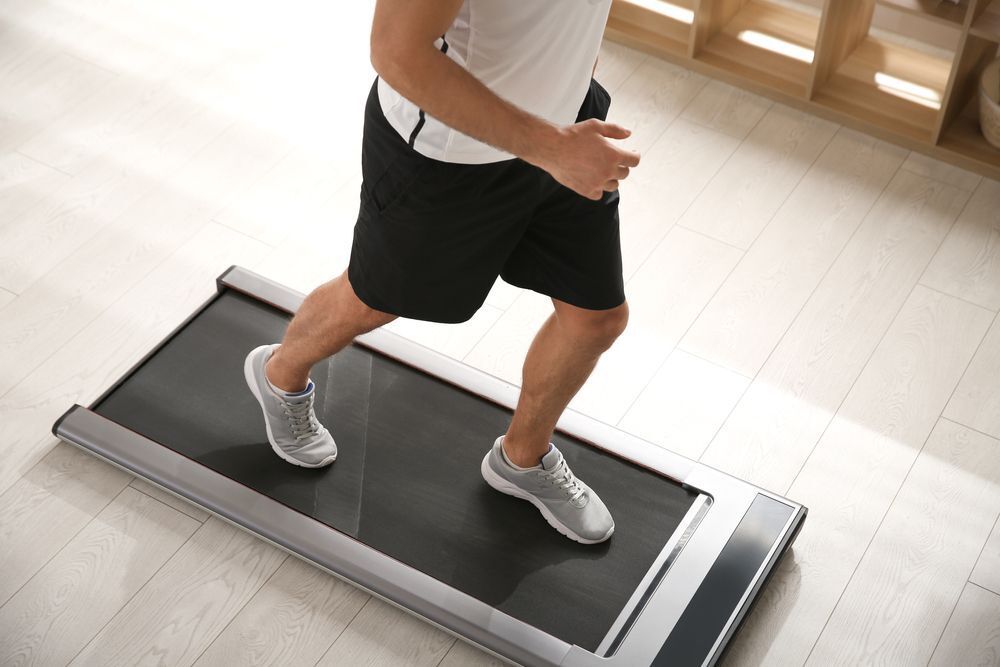 A man training on a walking treadmill. 