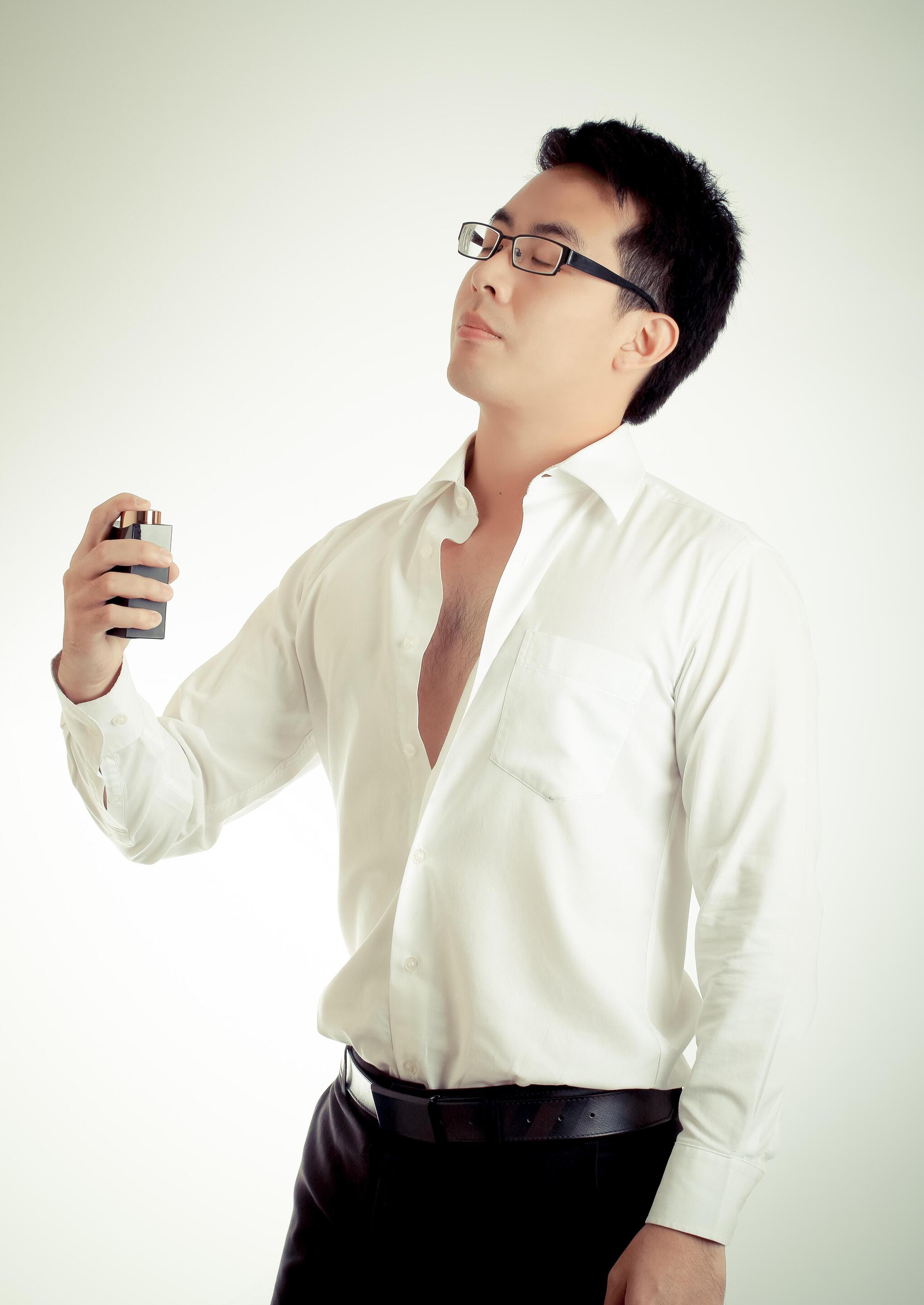 Asian man spraying deodorant