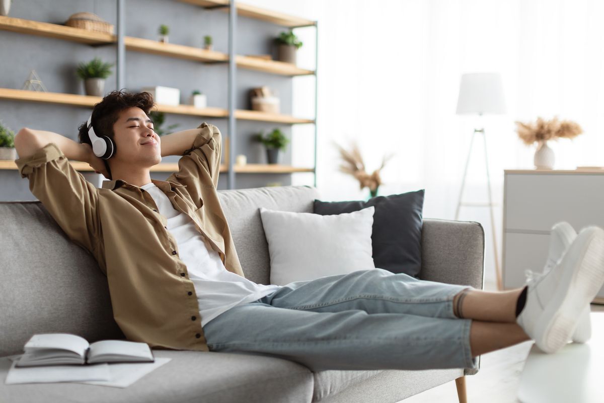 Asian man feet up on the table while listening to music