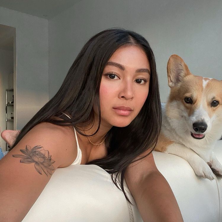 Asian woman with long hair posing with her Corgi