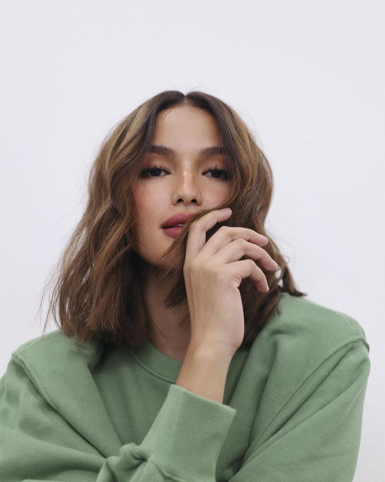 Asian woman with short and wavy brown hair