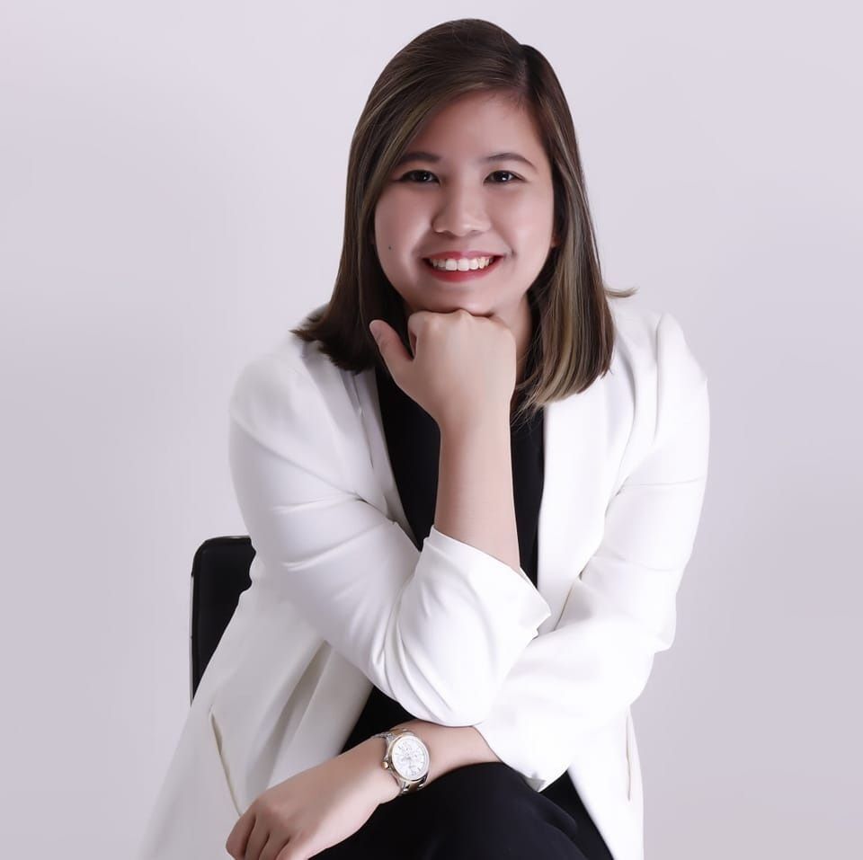 Smiling woman in white blazer.