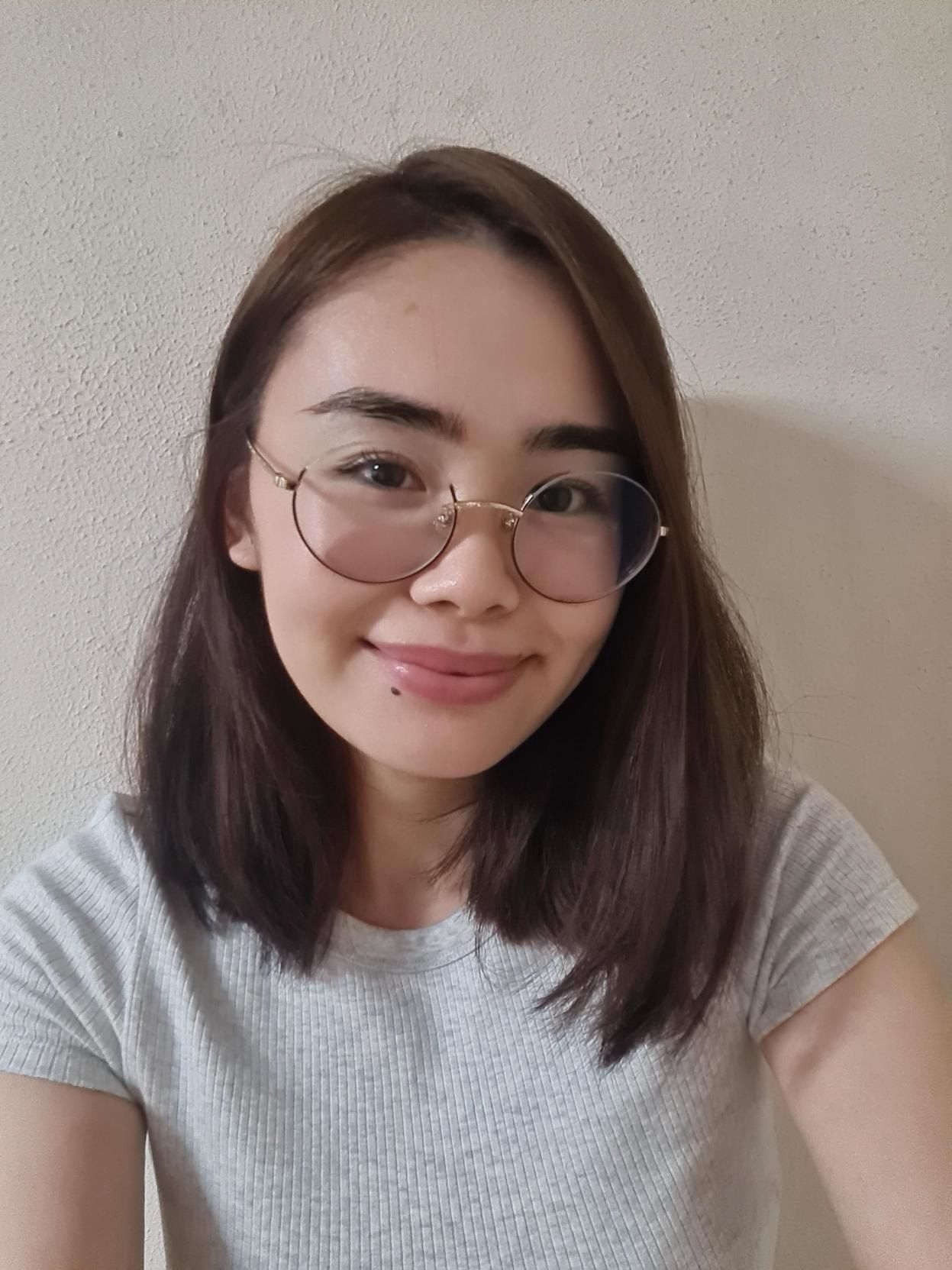 Woman with glasses and shoulder-length hair smiling at the camera.