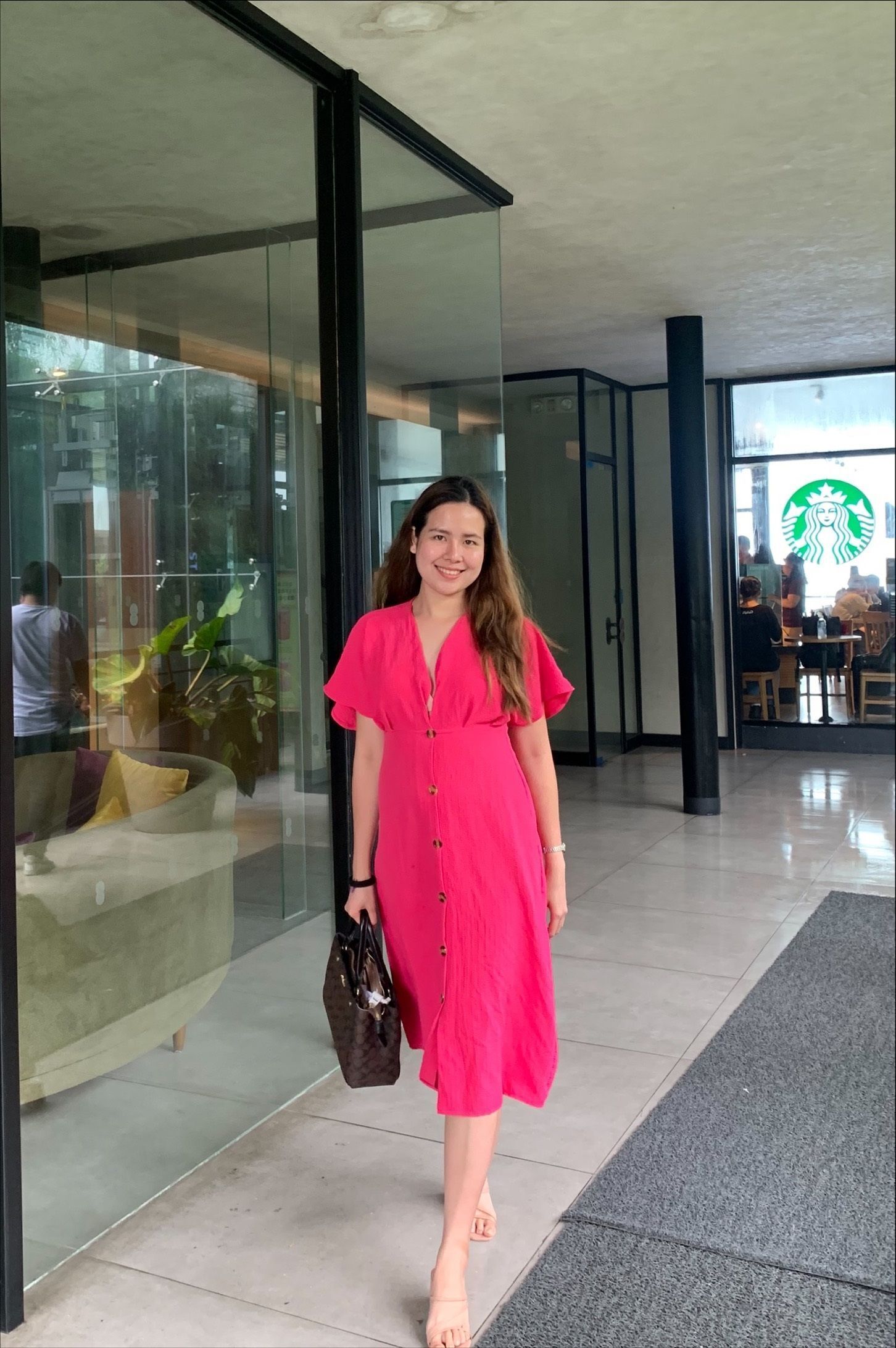 Woman in pink maxi dress posing in front of the camera.