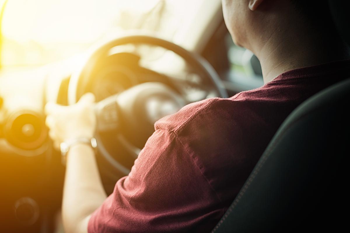 Back view of a man driving a car