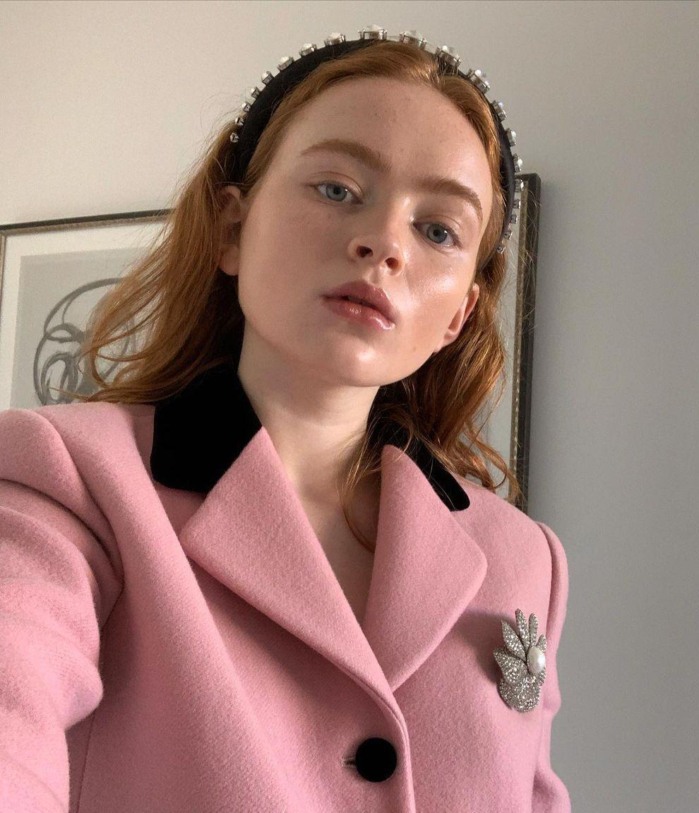 Woman wearing an embellished headband and pink jacket