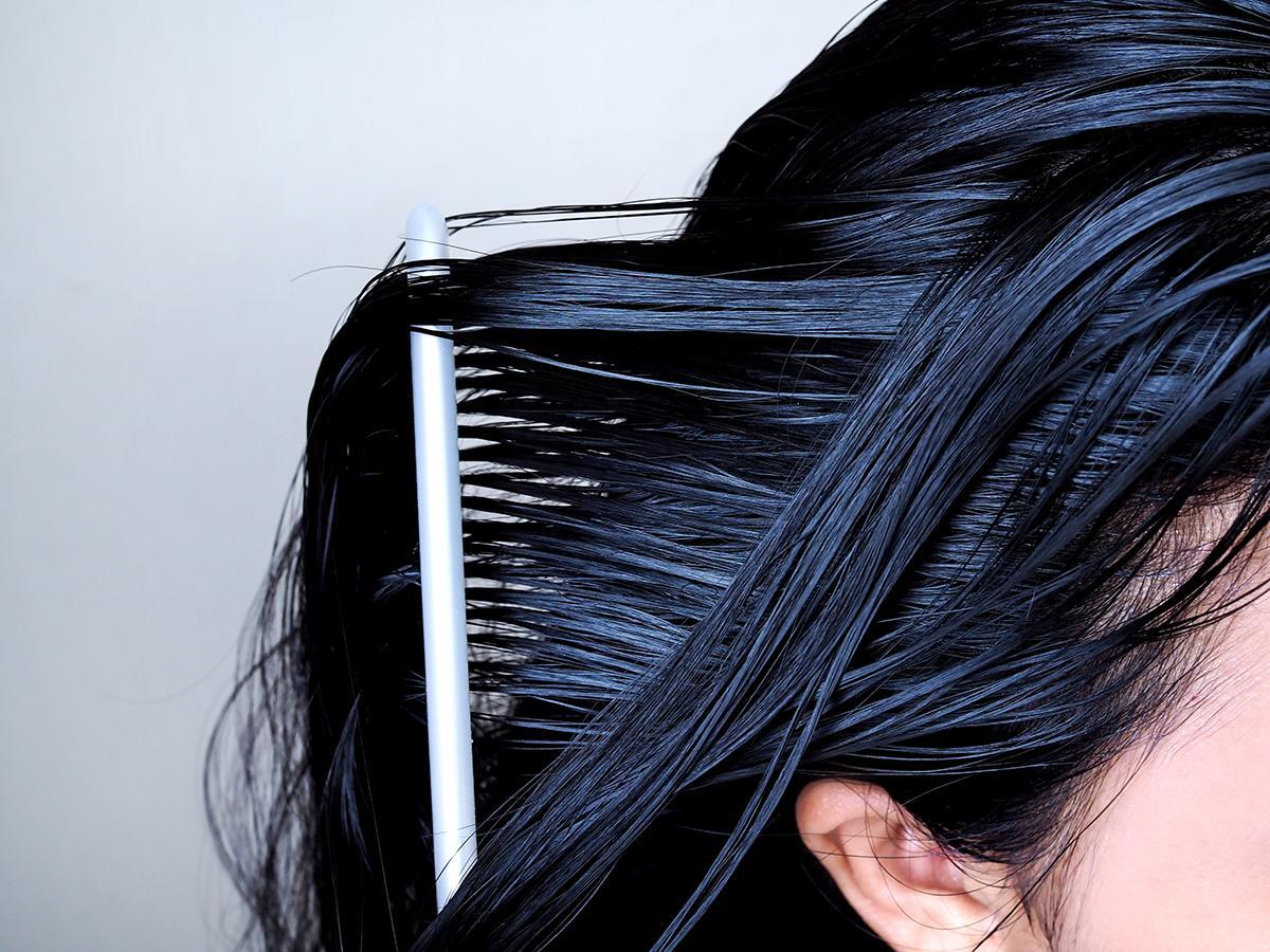 Asian woman combing her black hair