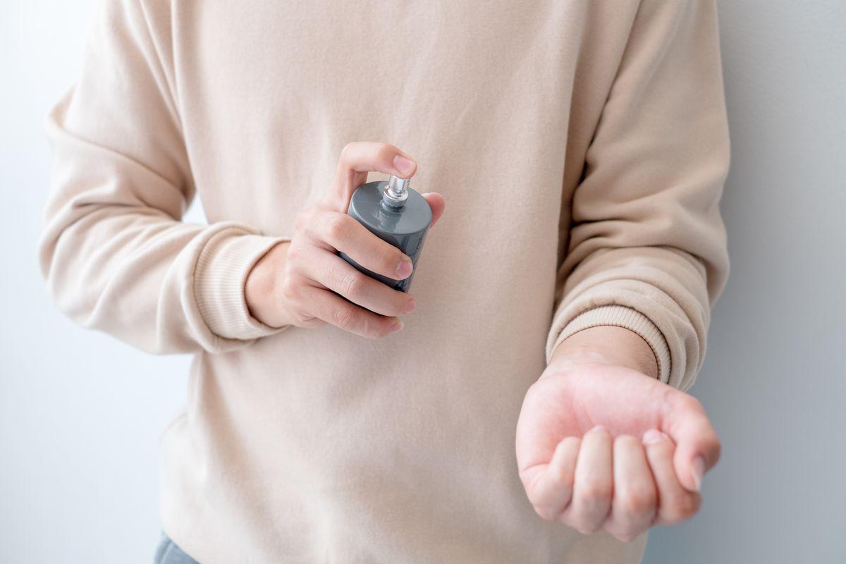 Man spraying perfume on wrist 