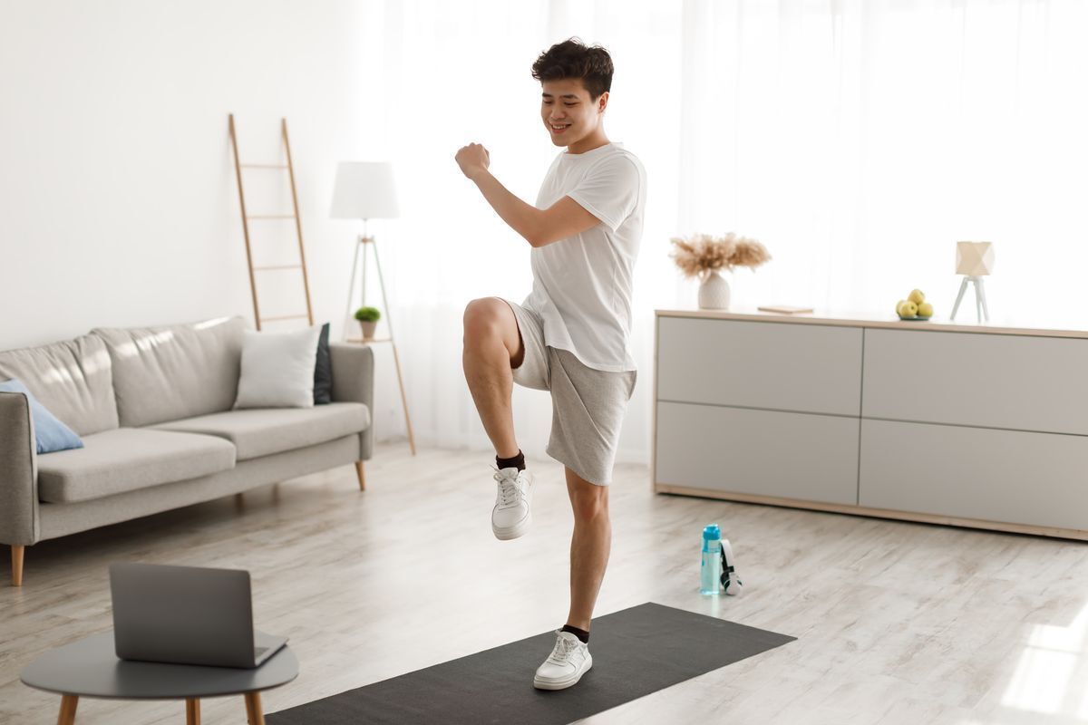 Man is exercising on a mat in his living room.