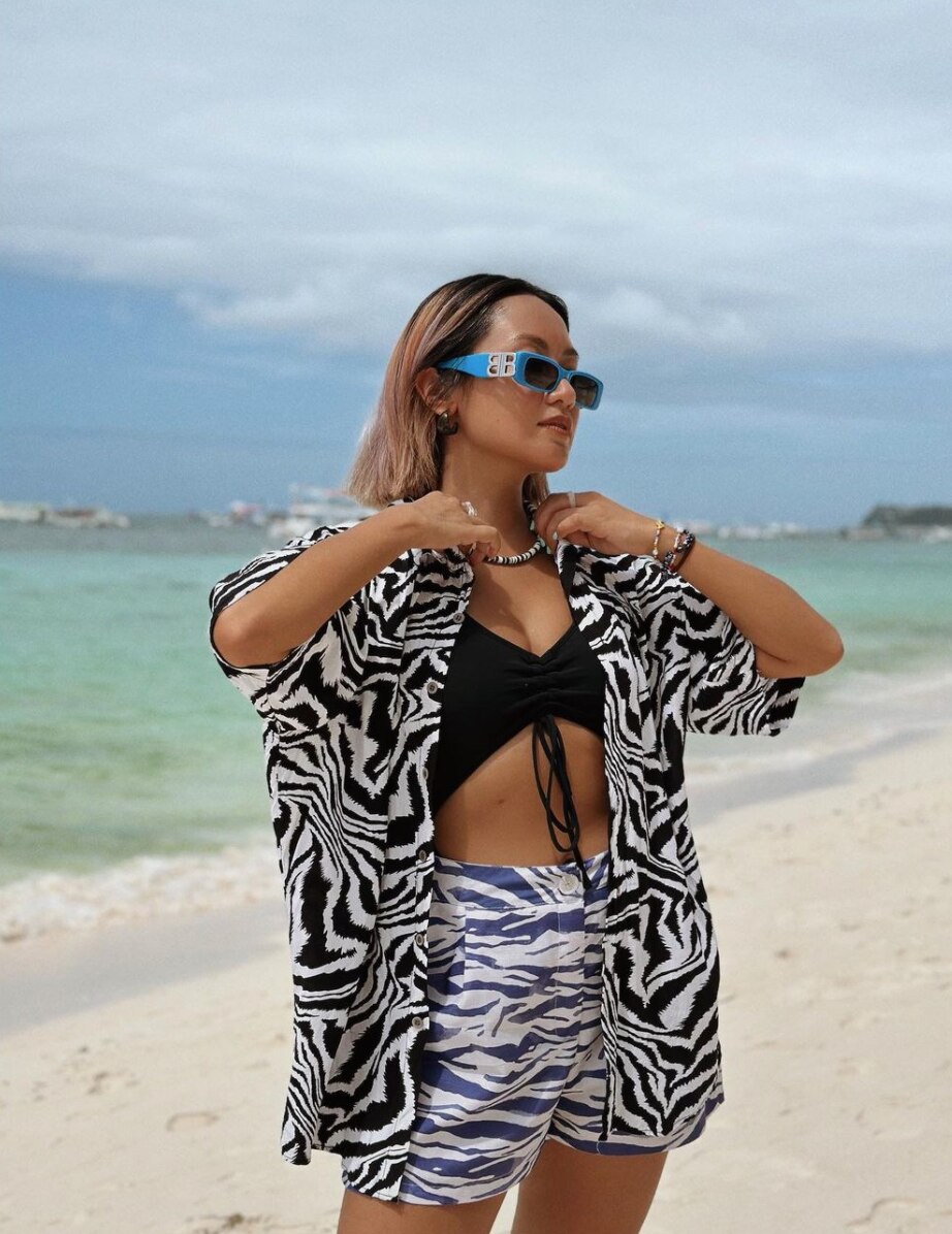 Asian woman in a matching zebra print top and shorts at the beach. 