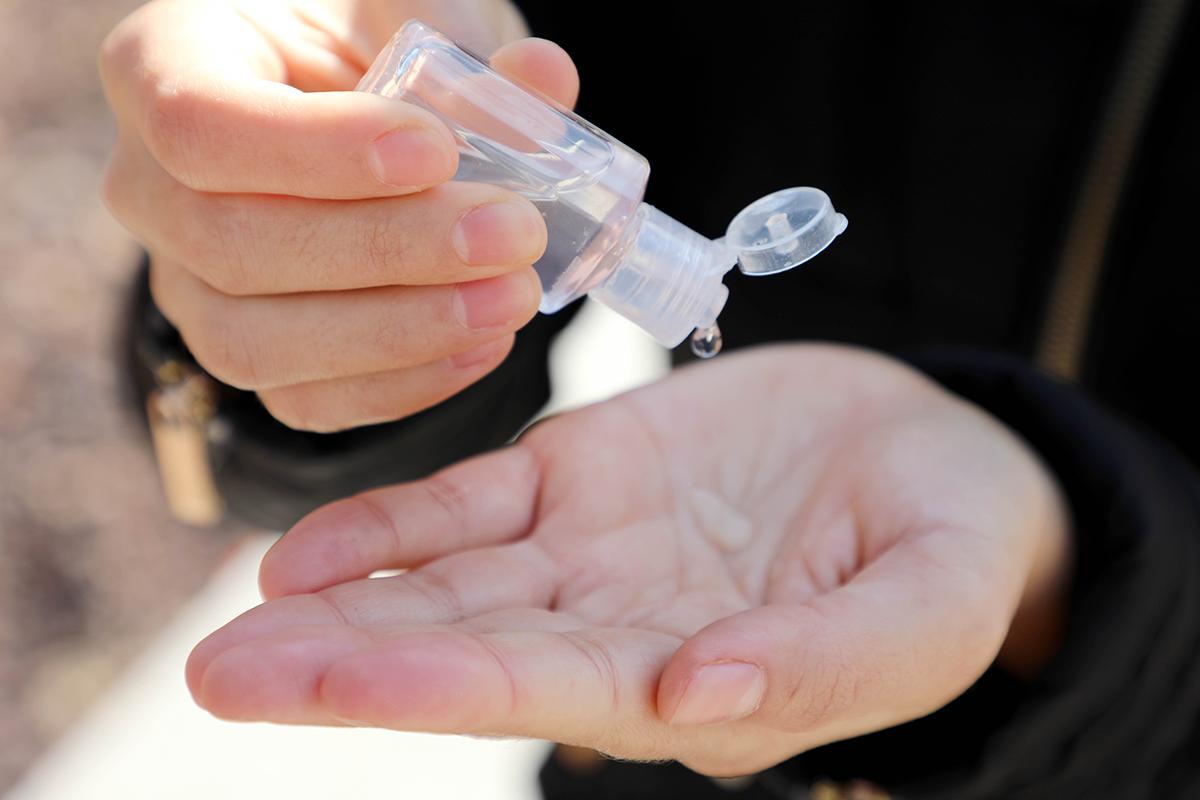 Closeup of a woman using hand sanitizer