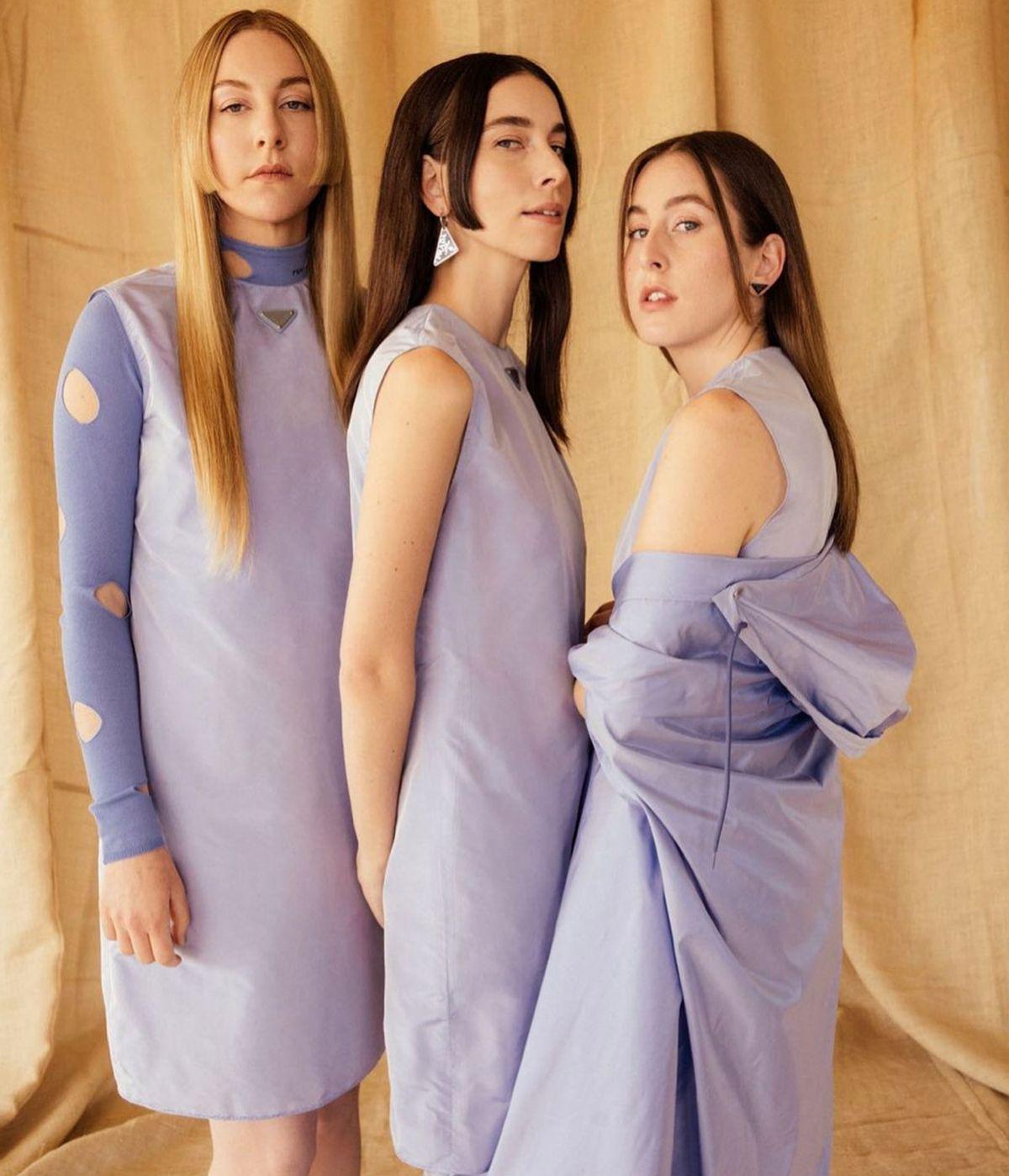 Three white women wearing matching lilac outfits 