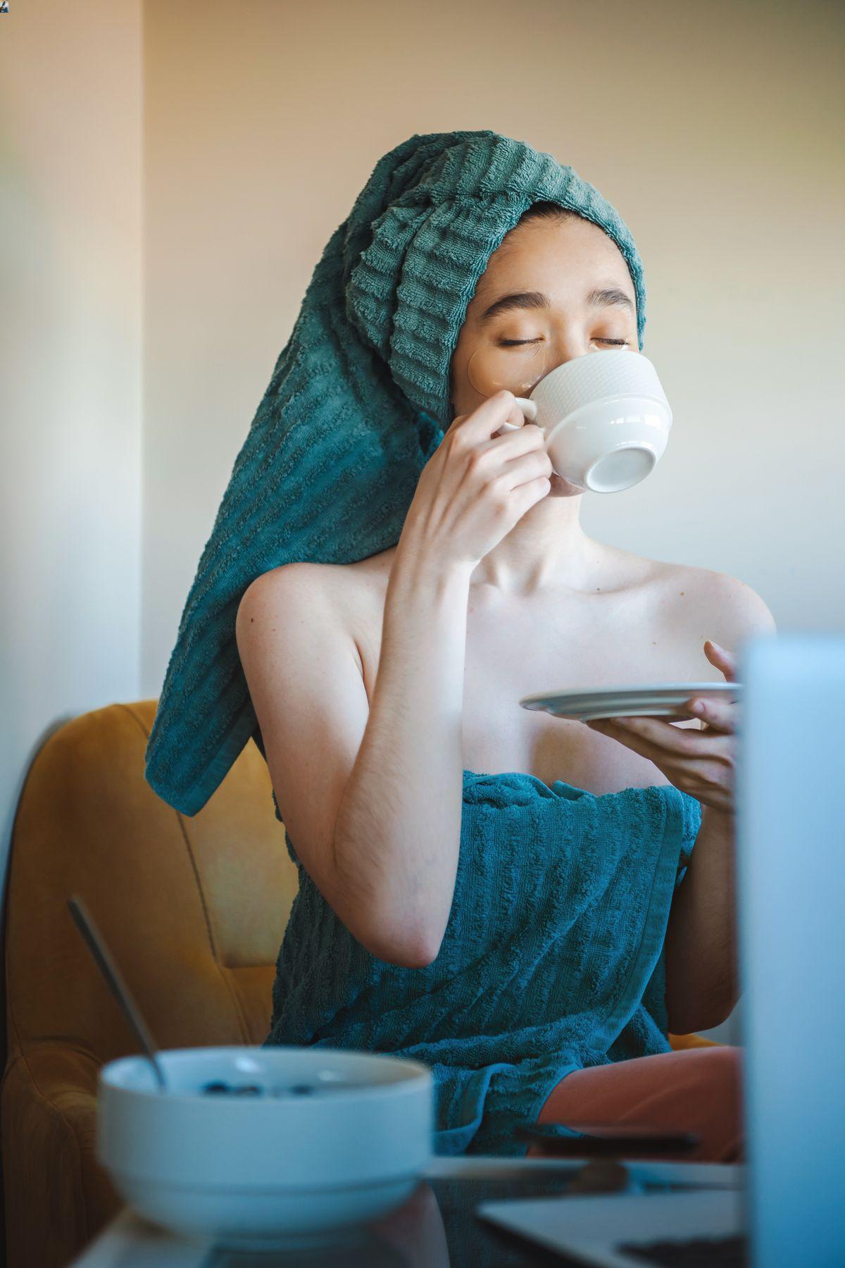 Asian woman drinking tea in robe