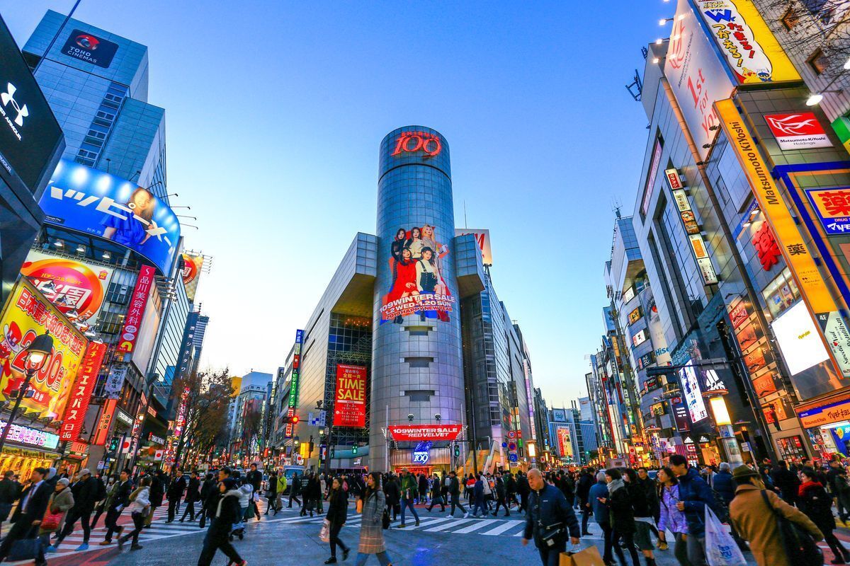 Wide image of buildings and lights at Shibuya crossing in Tokyo