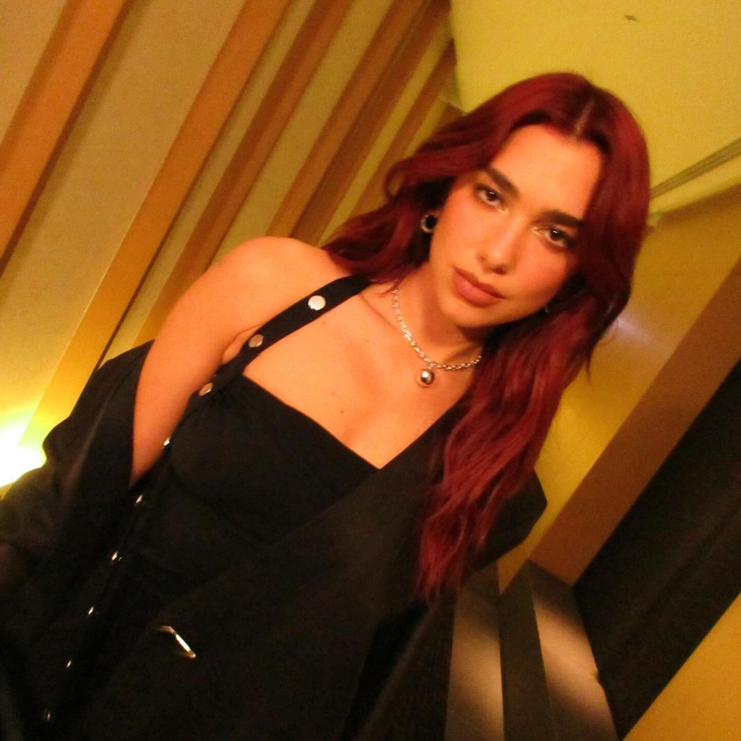 A portrait of Dua Lipa with long, red hair.