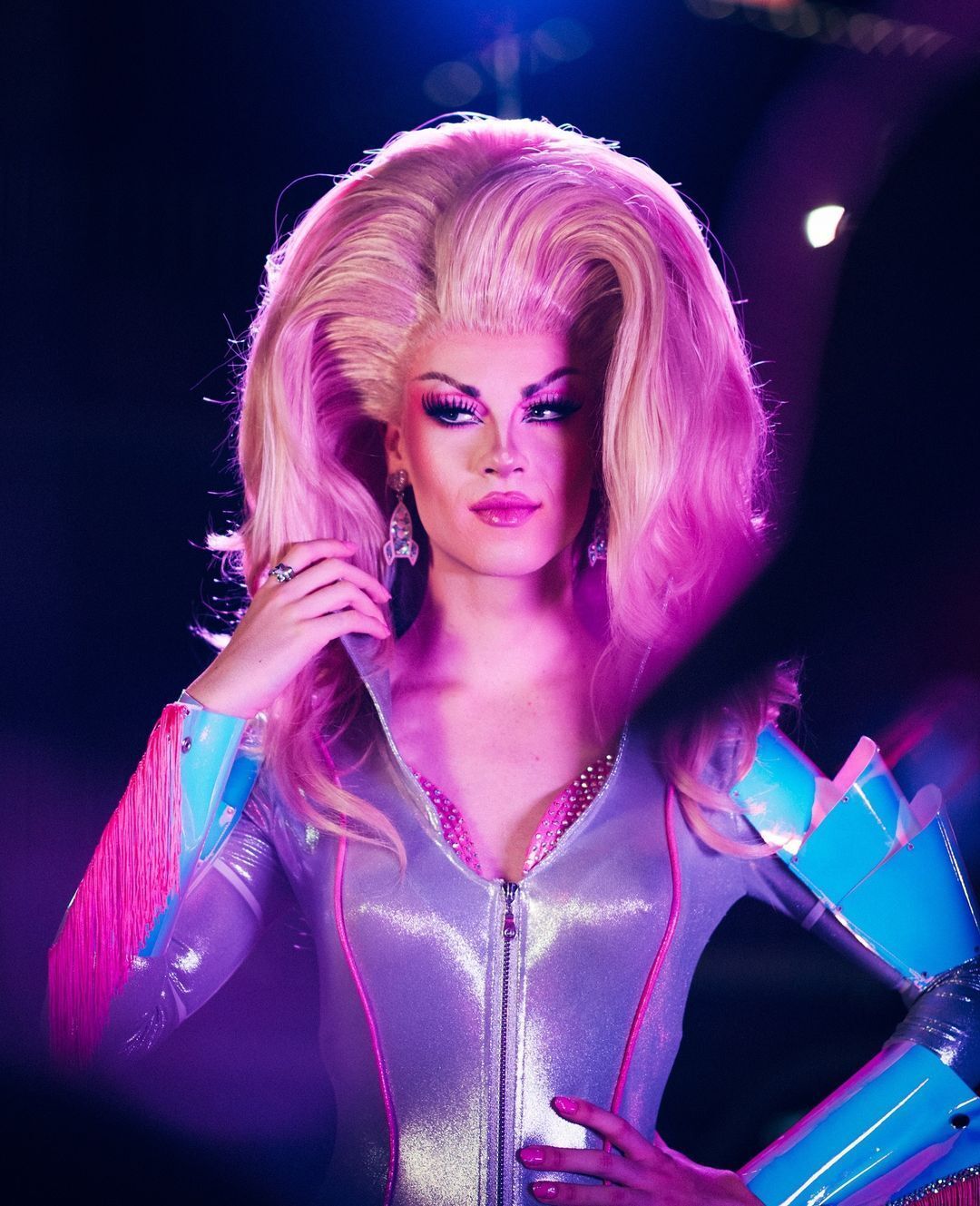 A portrait of drag queen with big hair and futuristic-style outfit.