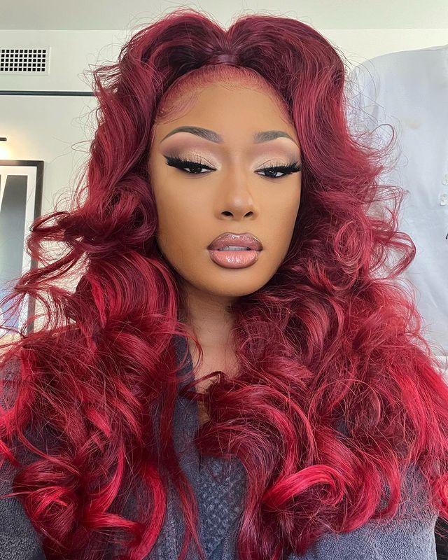 Megan Thee Stallion with red, curly high ponytail and laid edges. 