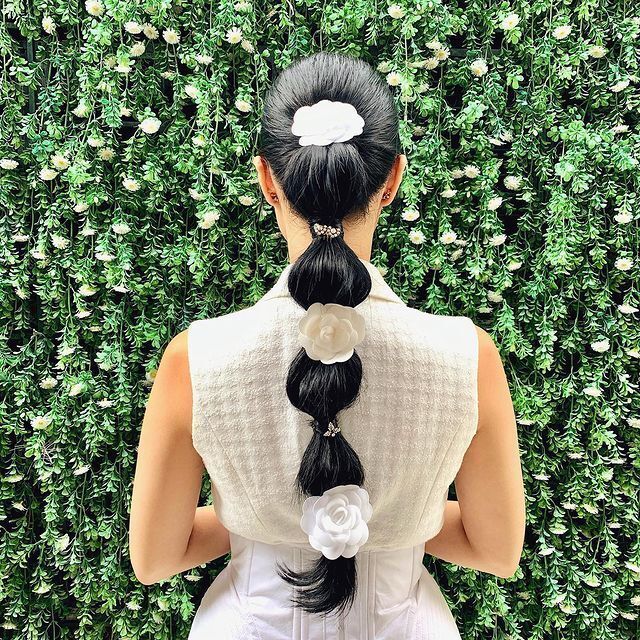 Heart Evangelista rocking the bubble ponytail with white rose hair accessories.
