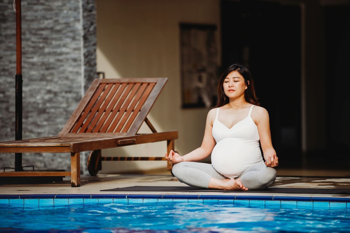Pregnant Asian woman by the water