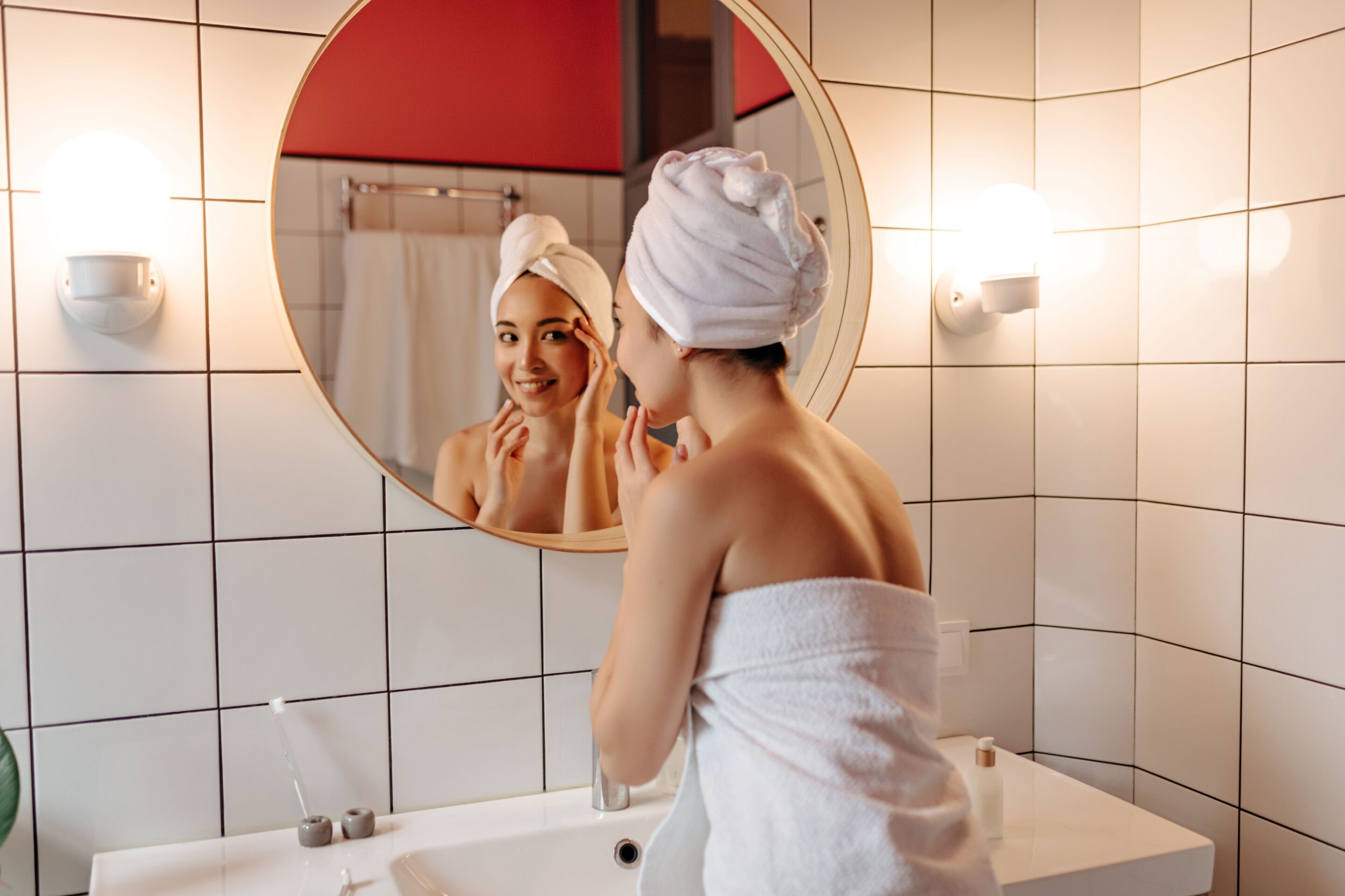Woman in the bathroom looking at herself in the mirror