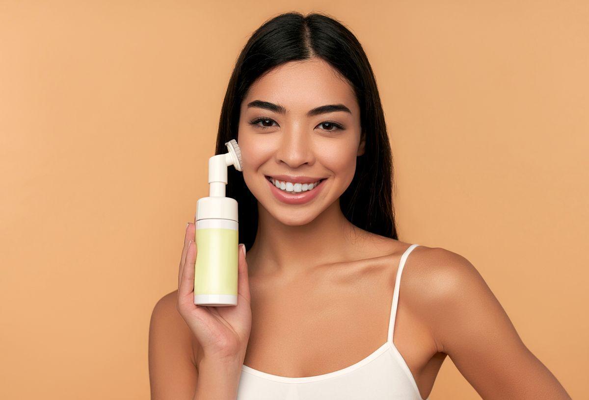 Asian woman with a facial cleansing device 