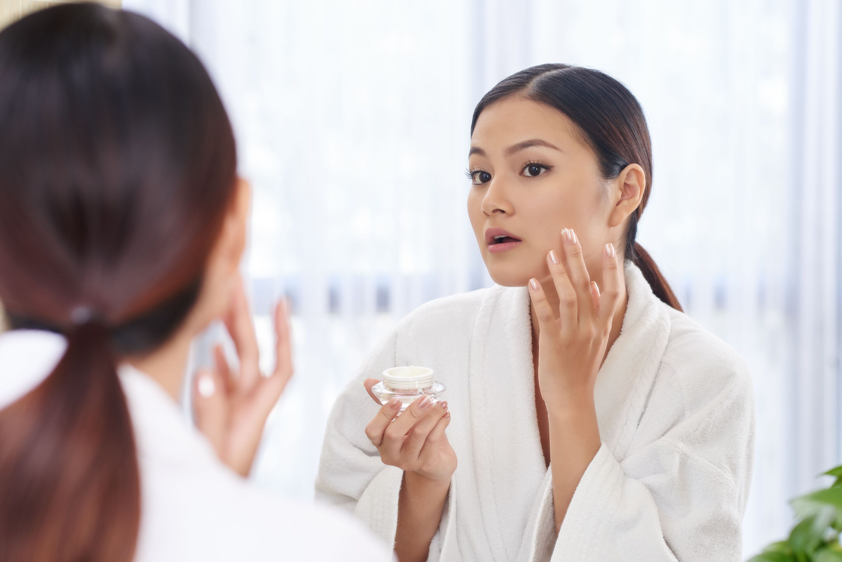 asian woman applying face cream