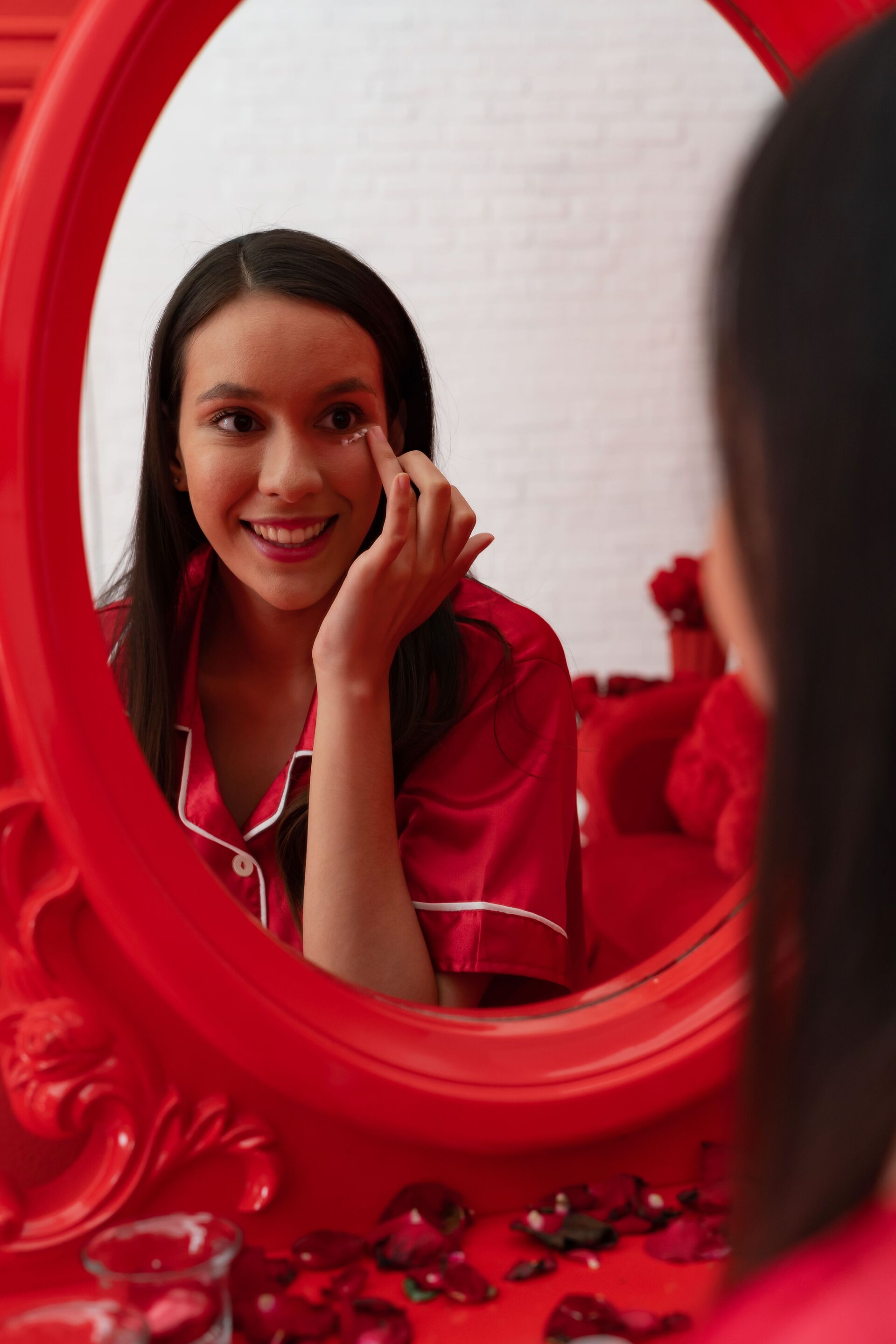 woman in red applying eye cream