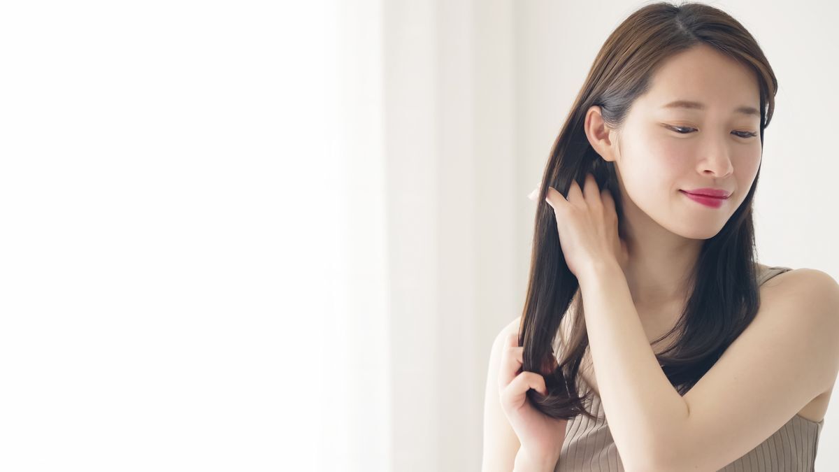 Asian woman stroking her hair