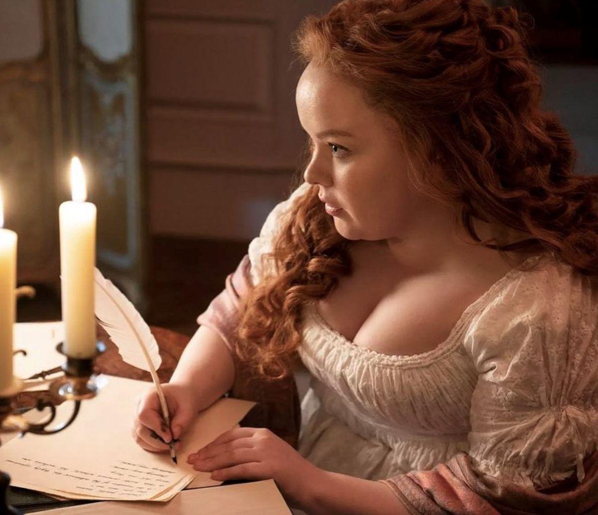 Woman with curly, red hair writing handwritten notes