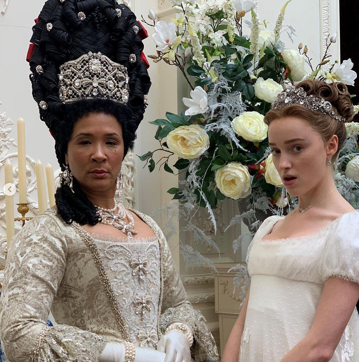 Two women wearing gowns and crowns