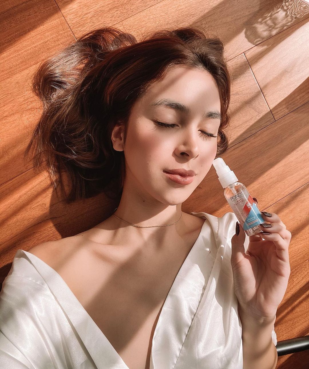 Filipina actress Julia Barretto lying on the floor holding a POND’S Face Mist product