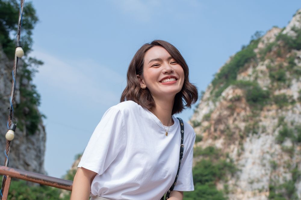 Woman in white T-shirt smiling to the camera.