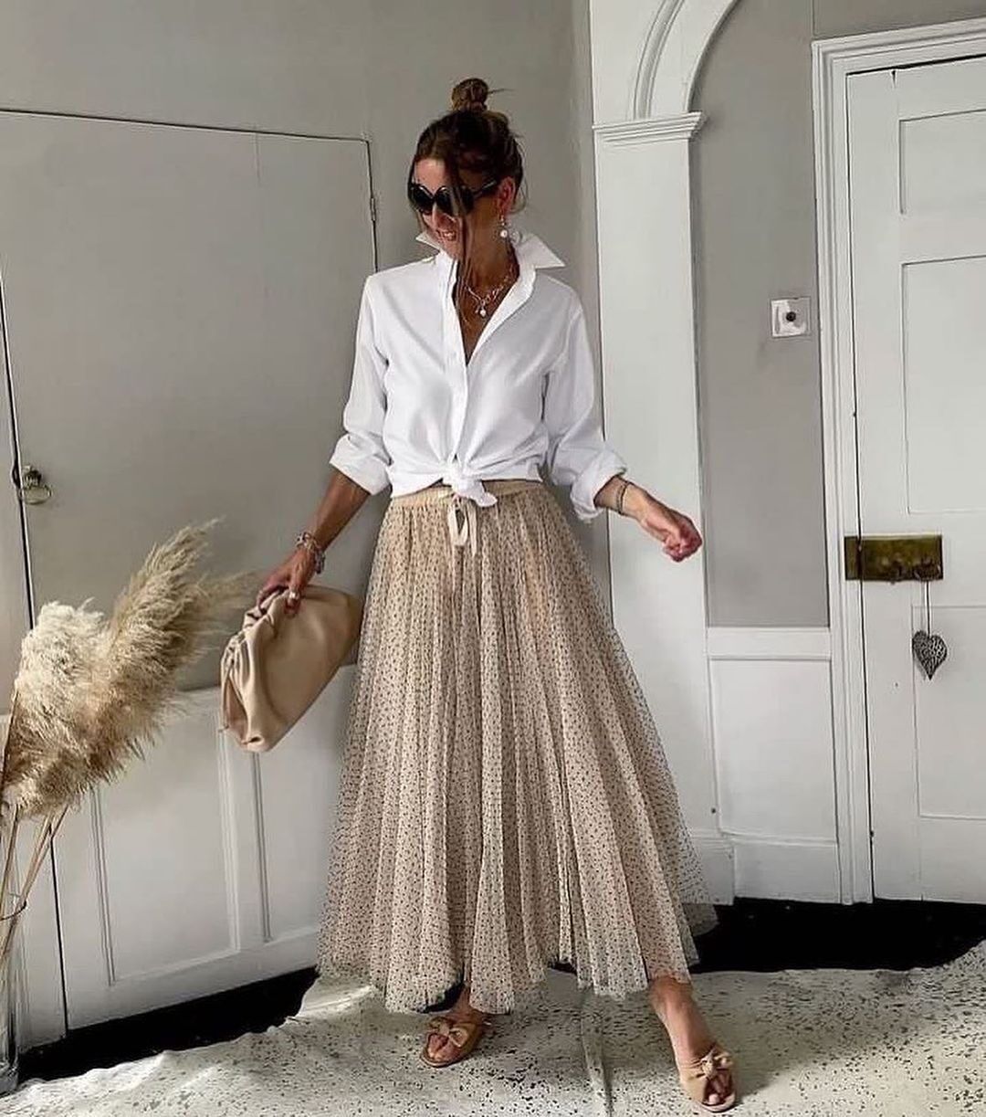 Woman wearing white dress shirt and long tutu skirt.