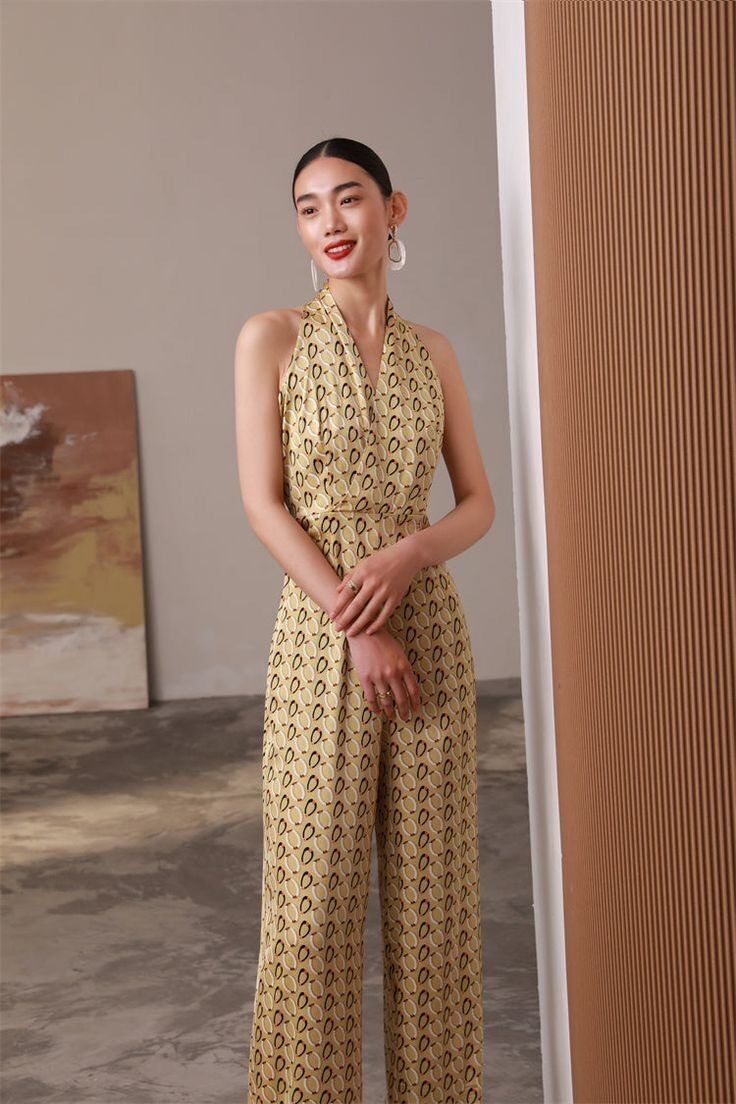 Woman wearing yellow jumpsuit with geometric prints.