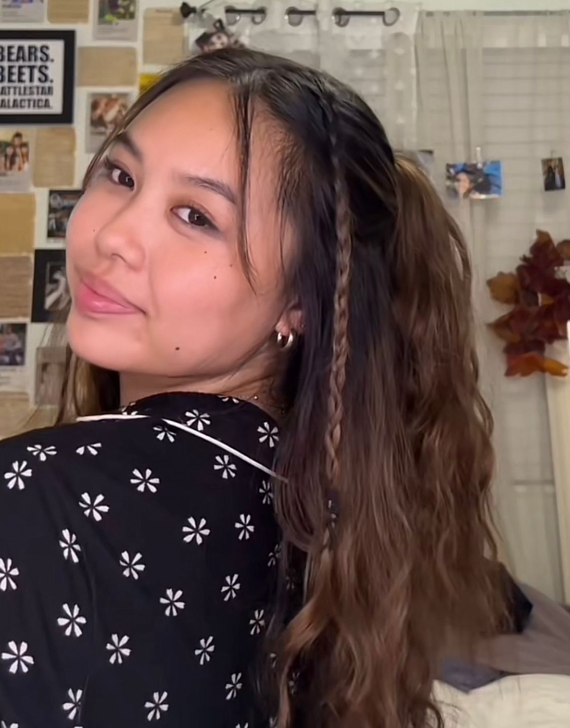 Woman with wavy half updo and baby braids.