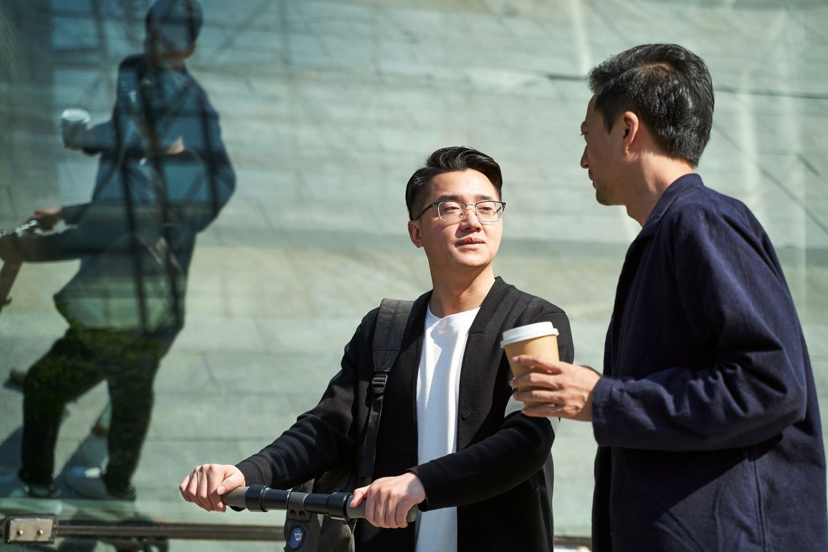 Two men talking face to face outdoor. 