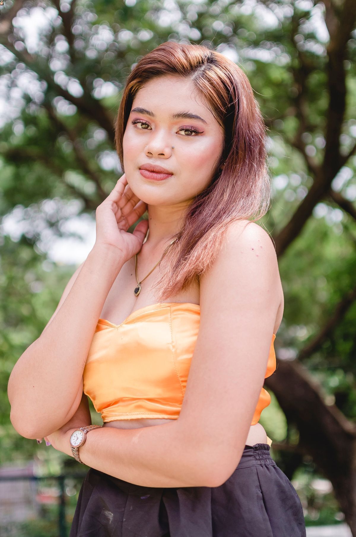 Asian woman in orange top with makeup