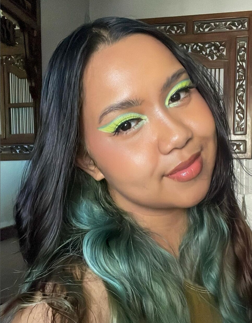 Filipino woman with green hair and green eyeshadow.