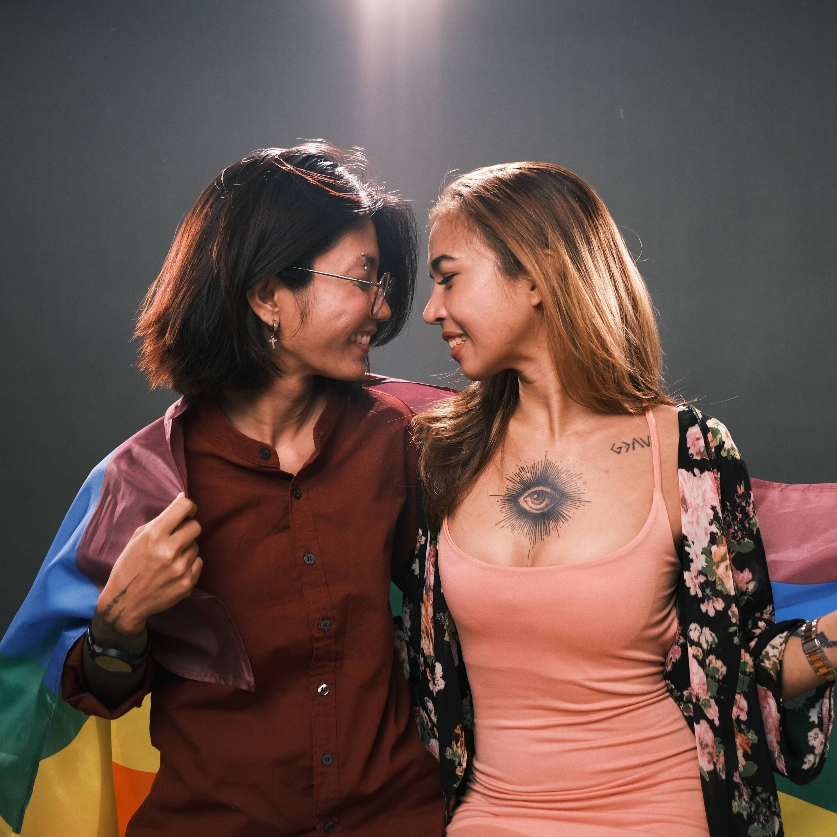 Two women holding the Pride flag.