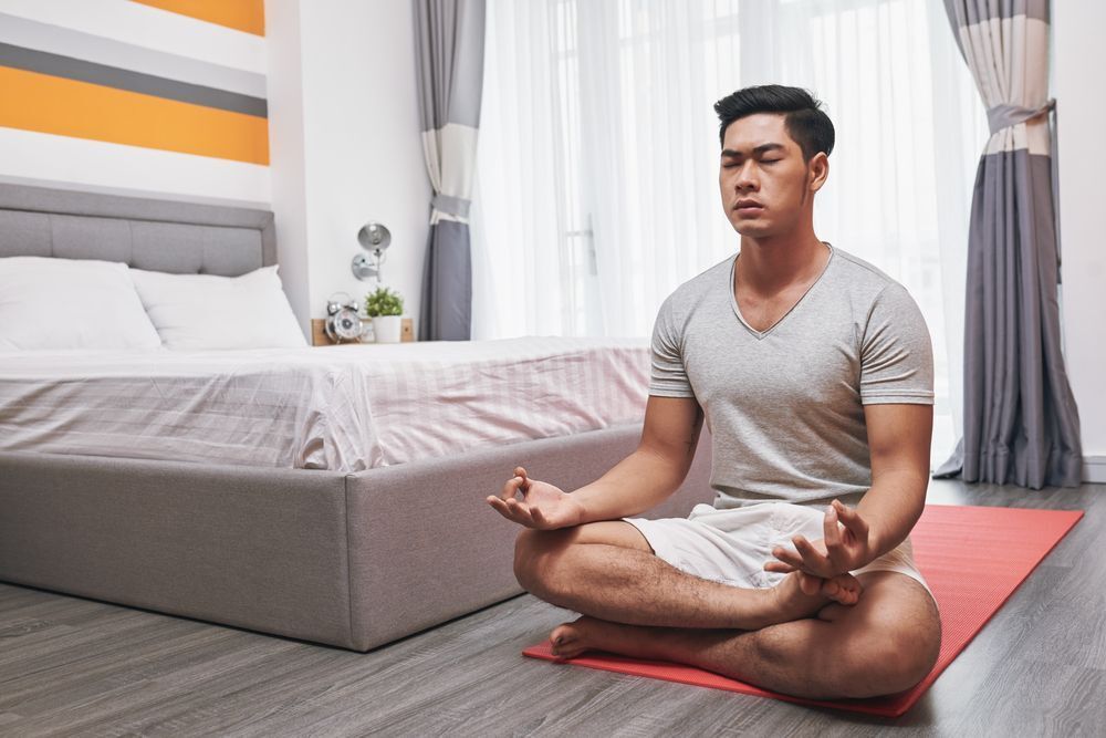 A man meditating in his room.