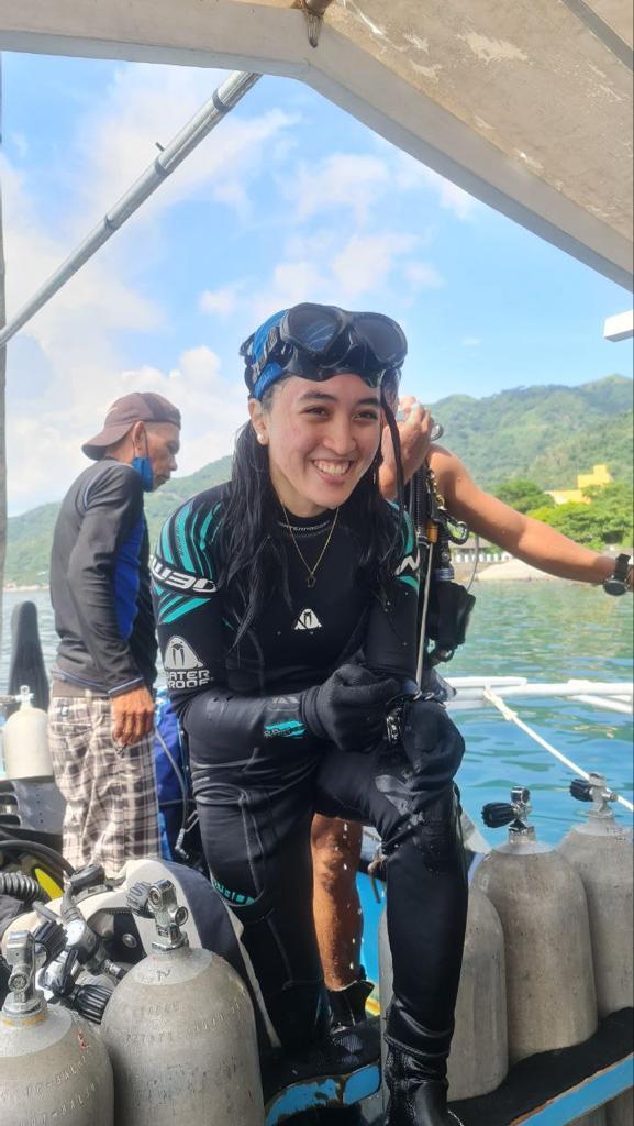 Asian girl on a boat with scuba diving gear.