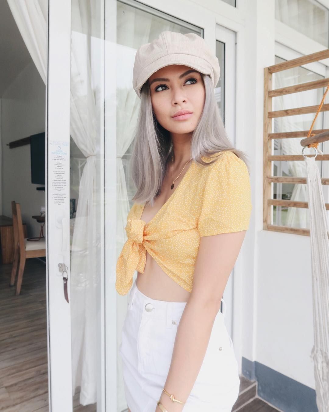 Sam Pinto with silver hair wearing yellow and white